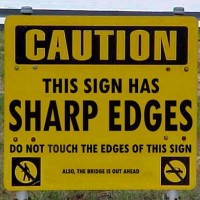 Caution. This Sign Has Sharp Edges. Do Not Touch the Edges of This Sign. Also, the Bridge is Out Ahead