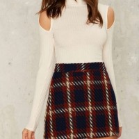 A turtleneck crop top and a plaid skirt